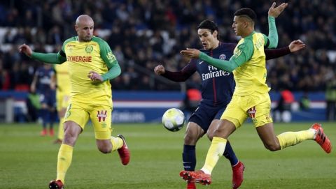 PSG's Edinson Cavani, center, challenges for the ball with Nantes' Nicolas Pallois, left, and Nantes' Diego Carlos, right, during their French League One soccer match between Paris-Saint-Germain and Nantes, at the Parc des Princes stadium in Paris, France, Saturday, Nov. 18, 2017. (AP Photo/Thibault Camus)