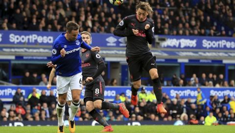 Arsenal's Mesut Ozil, right, scores his side's second goal against Everton during the English Premier League soccer match against Arsenal at the Goodison Park, Liverpool, England, Sunday Oct. 22, 2017. (Peter Byrne/PA via AP)