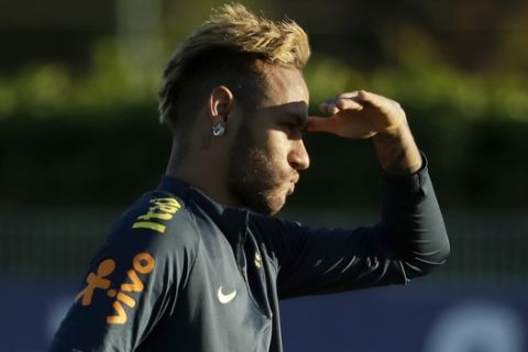 Brazil's Neymar shields his eyes from the sun during a Brazil national soccer squad training session at the training facilities of Tottenham Hotspur football club in Enfield, England, Tuesday, Oct. 9, 2018. (AP Photo/Matt Dunham)