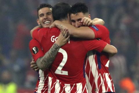 Atletico's Lucas Hernandez, left, Diego Godin, center, and José María Gimenez celebrate the 3-0 win of their team after the Europa League Final soccer match between Marseille and Atletico Madrid at the Stade de Lyon in Decines, outside Lyon, France, Wednesday, May 16, 2018. (AP Photo/Thibault Camus)