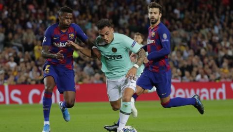 Barcelona's Nelson Semedo, left, tries to stop Inter Milan's Lautaro Martinez, center, during the group F Champions League soccer match between F.C. Barcelona and Inter Milan at the Camp Nou stadium in Barcelona, Spain, Wednesday, Oct. 2, 2019. (AP Photo/Emilio Morenatti)