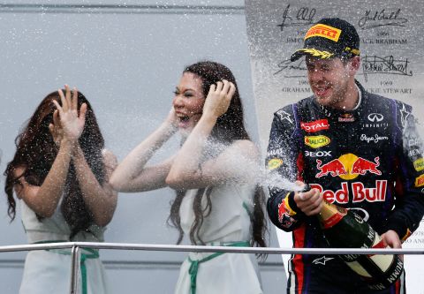 Malaysian grid girls react as Red Bull driver Sebastian Vettel of Germany sprays champagne after the awarding ceremony for the Malaysian Formula One Grand Prix at Sepang, Malaysia, Sunday, March 24, 2013. Vettel won the race.  (AP Photo/Andy Wong)