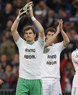 epa02637210 Real Madrid's Iker Casillas (L) and Esteban Granero (R) show their support to FC Barcelona's French player Eric Abidal, who has been diagnosed with a liver tumour and will be treated surgically on 18 March, at the end of their UEFA Champions League round of 16 second leg match against Olympique Lyon at Santiago Bernabeu Stadium in Madrid, Spain, on 16 March 2011. EPA/BALLESTEROS
