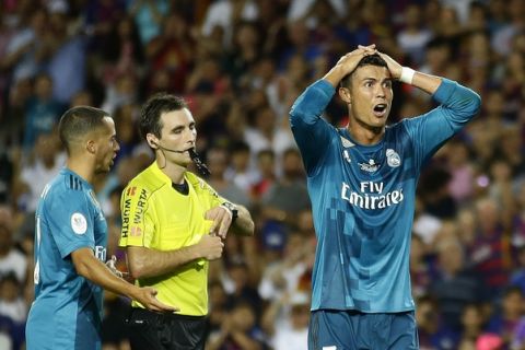 Real Madrid's Cristiano Ronaldo, right, reacts after Referee Ricardo de Burgos shows a yellow card during the Spanish Supercup, first leg, soccer match between FC Barcelona and Real Madrid at the Camp Nou stadium in Barcelona, Spain, Sunday, Aug. 13, 2017. (AP Photo/Manu Fernandez)