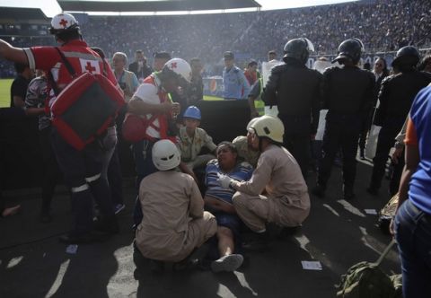 An injured man is assisted after a deadly stampede at the National Stadium in Tegucigalpa, Honduras, Sunday, May 28, 2017. Thousands of soccer fans trying to force their way into a stadium for a championship match stampeded in panic when police fired tear gas Sunday, and several were killed in the crush and over a dozen others were injured, authorities said. (AP Photo/Fernando Antonio)