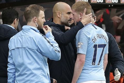 Manchester City manager Pep Guardiola consoles injured player Kevin De Bruyne as he leaves the pitch during the  English Premier League soccer match between Bournemouth and Manchester City,  at the Vitality Stadium, in  Bournemouth, England, Saturday March 2, 2019. (Adam Davy/PA via AP)