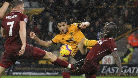 Wolverhampton's Raul Jimenez, centre, Liverpool's James Milner, left, and Liverpool's Sadio Mane challenge for the ball during the English Premier League soccer match between Wolverhampton Wanderers and Liverpool at the Molineux Stadium in Wolverhampton, England, Friday, Dec. 21, 2018. (AP Photo/Rui Vieira)
