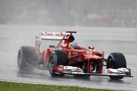 Ferrari Formula 1 car driver Fernando Alonso, of Spain,  drives his car under rain during the qualifying session at the Silverstone circuit, England, Saturday, July 7, 2012. The Formula 1 teams make preparations ahead of the British Grand Prix at Silverstone circuit on Sunday. (AP Photo/Lefteris Pitarakis)
