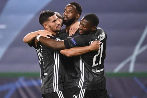Lyon's Moussa Dembele, centre, its congratulated by his teammates after scoring his team's second goal during the Champions League quarterfinal match between Manchester City and Lyon at the Jose Alvalade stadium in Lisbon, Portugal, Saturday, Aug. 15, 2020. (Franck Fife/Pool Photo via AP)