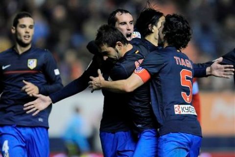 Atletico de Madrid's  Diego Godin from Uruguay, third  right to left, celebrates his goal with his fellow teammate after scored against Osasuna during their Spanish La Liga soccer match, at Reyno de Navarra stadium in Pamplona, northern Spain, Monday, Jan. 30, 2012. (AP Photo/Alvaro Barrientos)