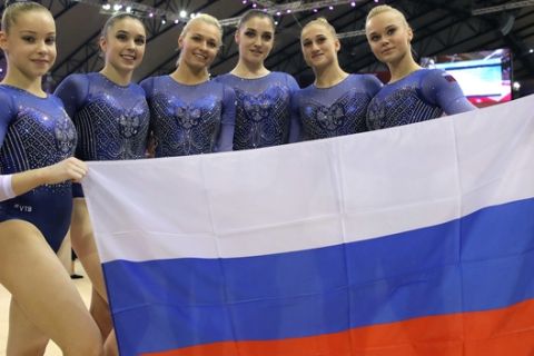 Second place team Russia poses with the national flag after the women's team final of the Gymnastics World Chamionships at the Aspire Dome in Doha, Qatar, Tuesday, Oct. 30, 2018. (AP Photo/Vadim Ghirda)