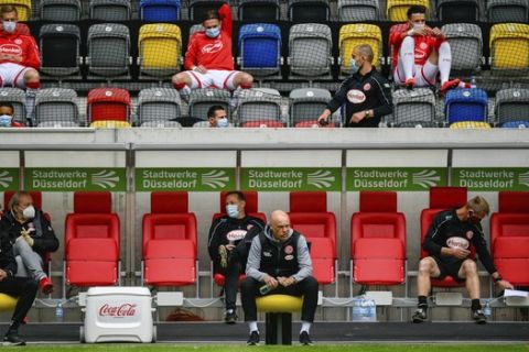 Fortuna Duesseldorf's German head coach Uwe Roesler sits on the sideline during the Bundesliga soccer match between Duesseldorf and  Paderborn in the Merkur Spiel-Arena, Duesseldorf, Germany, Saturday, May 16, 2020. The German Bundesliga becomes the world's first major soccer league to resume after a two-month suspension because of the coronavirus pandemic. (Sascha Schuermann/AFP pool via AP)