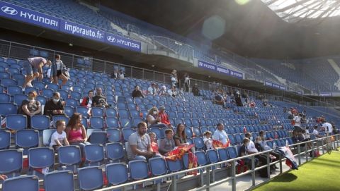 Spectators sit in the rows of Le Havre stadium prior to the friendly soccer match between Paris Saint Germain and Le Havre, in Le Havre, western France, Sunday, July 12, 2020. For the first time since the coronavirus shut down sports and chased away spectators, Neymar, Kylian Mbappe and other soccer stars are going to play again in front of fans. (AP Photo/Thibault Camus)