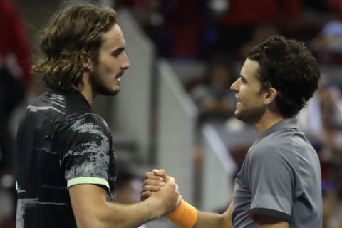 Dominic Thiem of Austria, right, is congratulated by Stefanos Tsitsipas of Greece after defeating Tsitsipas in their men's singles championship match at the China Open tennis tournament in Beijing, Sunday, Oct. 6, 2019. (AP Photo/Mark Schiefelbein)