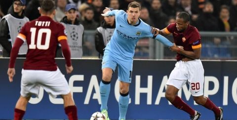 Manchester City's Bosnian striker Edin Dzeko (C) vies with Roma's midfielder from Mali Seydou Keita during the UEFA Champions League football match AS Roma vs Manchester City on December 10, 2014 at the Olympic stadium in Rome.      AFP PHOTO / GABRIEL BOUYS        (Photo credit should read GABRIEL BOUYS/AFP/Getty Images)