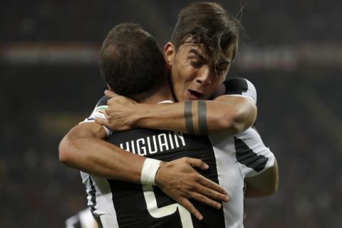 Juventus' Paulo Dybala hugs teammate Gonzalo Higuain who scored his side's first goal during a Serie A soccer match between AC Milan and Juventus, at the Milan San Siro stadium, Italy, Saturday, Oct. 28, 2017. (AP Photo/Luca Bruno)