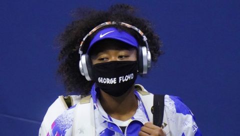 Naomi Osaka, of Japan, wears a protective mask due to the COVID-19 virus outbreak, featuring the name "George Floyd", while arriving on court to face Shelby Rogers, of the United States, during the quarterfinal round of the US Open tennis championships, Tuesday, Sept. 8, 2020, in New York. (AP Photo/Frank Franklin II)