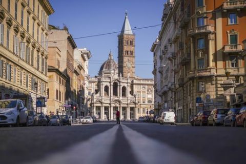 A person crosses an empty street, in front of St. Mary Major Basilica, in Rome, Tuesday, March 24, 2020. For most people, the new coronavirus causes only mild or moderate symptoms. For some it can cause more severe illness, especially in older adults and people with existing health problems. (AP Photo/Andrew Medichini)