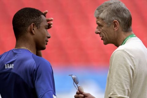 Arsene Wenger, right, coach of English soccer club Arsenal, talks to Arsenal's Brazilian player Gilberto Silva at the end of a training session of Brazil's national soccer team Tuesday, June 21, 2005, at the stadium in Cologne, Germany. Brazil will play Japan in their third game of the Confederations Cup Wednesday in Cologne. (AP Photo/Armando Franca)