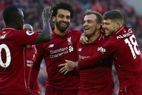 Liverpool's Xherdan Shaqiri, second right,  celebrates scoring his side's third goal of the game with Sadio Mane,left, Mohamed Salah and Alberto Moreno during the English Premier League soccer match between Liverpool and Cardiff City at Anfield, in Liverpool, England, Saturday, Oct. 27, 2018. (Dave Thompson/PA via AP)