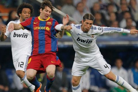 FC Barcelona's Lionel Messi from Argentina, center, vies for the ball with Real Madrid's Marcelo from Brazil, left, and Sergio Ramos, right, during a semifinal, 1st leg, Champions League soccer match at the Santiago Bernabeu stadium in Madrid, Wednesday, April 27, 2011. (AP Photo/Arturo Rodriguez)