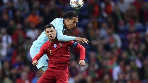 Netherlands' Virgil Van Dijk, background, heads the ball past Portugal's Cristiano Ronaldo during the UEFA Nations League final soccer match between Portugal and Netherlands at the Dragao stadium in Porto, Portugal, Sunday, June 9, 2019. (AP Photo/Martin Meissner)