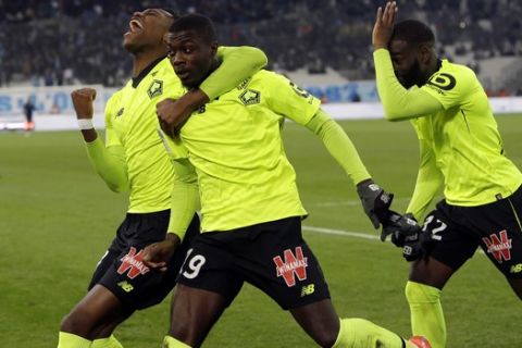 Lille's Nicolas Pepe, center, celebrates with teammates after scoring the first goal of the game during a French League One soccer match between Olympique Marseille and Lille at the Stade Velodrome in Marseille, France, Friday, Jan. 25, 2019. (AP Photo/Claude Paris)