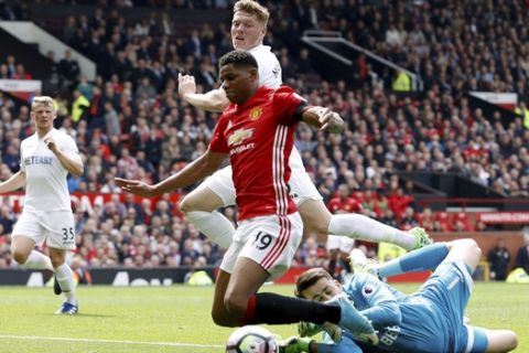 Manchester United's Marcus Rashford is bought down by Swansea City goalkeeper Lukasz Fabianski, awarded a penalty for the foul, during their English Premier League soccer match at Old Trafford in Manchester, England, Sunday April 30, 2017. (Martin Rickett/PA via AP)