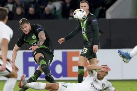 VfL Wolfsburg Wout Weghorst, center, passes the ball before Oleksandria Dmytro Hrechyshkin can defend during the Europa League Group I soccer match between Vfl Wolfsburg  and Oleksandria at Volkswagen Arena in Wolfsburg, Germany, Thursday, Sept. 19, 2019. (Peter Steffen/DPA via AP)