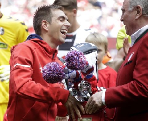 Bayern president Uli Hoeness, right, hands over a golf bag to Bayern's Philipp Lahm during his farewell celebration prior to the German first division Bundesliga soccer match between FC Bayern Munich and SC Freiburg at the Allianz Arena stadium in Munich, Germany, Saturday, May 20, 2017. (AP Photo/Matthias Schrader)