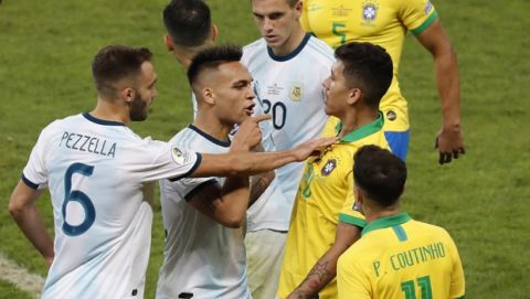 Argentina's Lautaro Martinez, second from left, and German Pezzella, left, face to Brazil's Roberto Firmino during a Copa America semifinal soccer match at the Mineirao stadium in Belo Horizonte, Brazil, Tuesday, July 2, 2019. (AP Photo/Nelson Antoine)