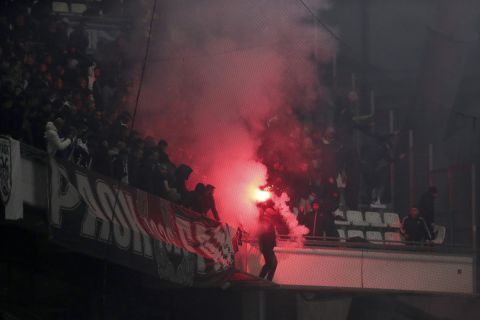 A fan of PAOK holds a flare ahead of the Europa Conference League quarterfinal soccer match between Olympique Marseille and PAOK FC at the Velodrome stadium in Marseille, southern France, Thursday, April 7, 2022. (AP Photo/Daniel Cole)