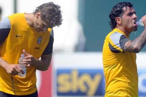 Juventus player Carlos Tevez (R) drinks water near team mate Fernando Llorente during a training session in Chatillon, in Valle d'Aosta, July 12, 2013. 
REUTERS/Giorgio Perrottino (ITALY - Tags: SPORT SOCCER)