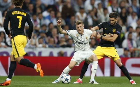 Real Madrid's Toni Kroos fights for the ball against Atletico's Yannick Carrasco during the Champions League semifinal first leg soccer match between Real Madrid and Atletico Madrid at the Santiago Bernabeu stadium in Madrid, Spain, Tuesday, May 2, 2017. (AP Photo/Francisco Seco)