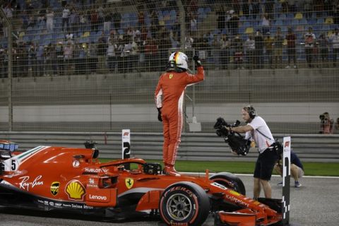 Ferrari driver Sebastian Vettel of Germany celebrates after getting the pole position in the qualifying session for the Bahrain Formula One Grand Prix, at the Formula One Bahrain International Circuit in Sakhir, Bahrain, Saturday, April 7, 2018. The Bahrain Formula One Grand Prix will take place here on Sunday. (AP Photo/Luca Bruno)