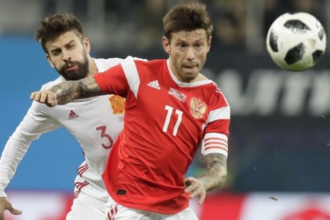 Russia's Fedor Smolov, right, struggles for the ball with Spain's Gerard Pique during the international friendly soccer match between Russia and Spain in St.Petersburg, Russia, Tuesday, Nov. 14, 2017. (AP Photo/Dmitri Lovetsky)