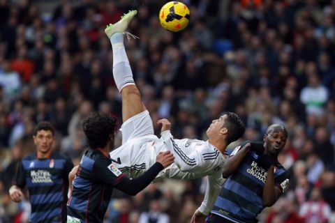FILE - In this Saturday, Jan. 25, 2014 file photo Real Madrid's Cristiano Ronaldo, of Portugal, top, tries to score in between opposition players during a Spanish La Liga soccer match between Real Madrid and Granada at the Santiago Bernabeu stadium in Madrid, Spain. (AP Photo/Andres Kudacki, File)