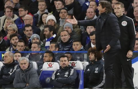 Manchester United head coach Jose Mourinho , left, watches as Chelsea's team manager Antonio Conte gestures during the English Premier League soccer match between Chelsea and Manchester United at Stamford Bridge stadium in London, Sunday, Nov. 5, 2017.(AP Photo/Frank Augstein)