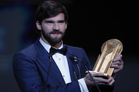Liverpool's Alisson Becker holds the Yachine Trophy after he awarded as the best goalkeeper during the Golden Ball award ceremony at the Grand Palais in Paris, Monday, Dec. 2, 2019. Awarded every year by France Football magazine since Stanley Matthews won it in 1956, the Ballon d'Or, Golden Ball for the best player of the year will be given to both a woman and a man. (AP Photo/Francois Mori)