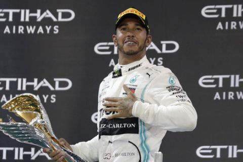 Mercedes driver Lewis Hamilton of Britain celebrates on the podium after winning the Emirates Formula One Grand Prix at the Yas Marina racetrack in Abu Dhabi, United Arab Emirates, Sunday, Dec.1, 2019. (AP Photo/Hassan Ammar)