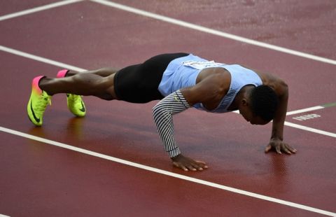 Botswana's Isaac Makwala does push ups as he celebrates after a men's 200-meter individual time trial during the World Athletics Championships in London Wednesday, Aug. 9, 2017. Makwala ran to qualify for the 200m semi-finals after he missed the 200m heats and the 400m final as he was barred from competing for 48 hours while organizers tried to halt a norovirus outbreak. (AP Photo/Martin Meissner)