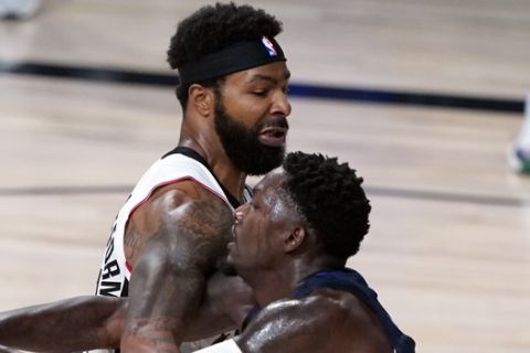 Dallas Mavericks' Dorian Finney-Smith (10), right, reaches for the ball as Los Angeles Clippers' Marcus Morris Sr. (31) defends during overtime of an NBA basketball first round playoff game Sunday, Aug. 23, 2020, in Lake Buena Vista, Fla. (AP Photo/Ashley Landis, Pool)