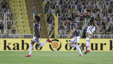 Fenerbahce's Luiz Gustavo Dias, left, celebrates with teammates after scoring during a Turkish Super League soccer match between Fenerbahce and Kayserispor in Istanbul, Friday, June 12, 2020. The Turkish Super Lig resumed its season on Friday without spectators after it had suspended games since March 20 due to the coronavirus pandemic, later than many other European leagues. (Erdem Sahin/Pool via AP)