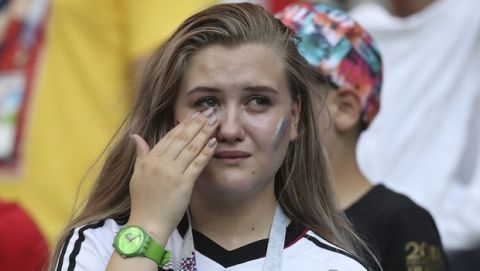 A german fan wipes tears from her yes at the end of the group F match between South Korea and Germany, at the 2018 soccer World Cup in the Kazan Arena in Kazan, Russia, Wednesday, June 27, 2018. South Korea won 2-0. (AP Photo/Thanassis Stavrakis)