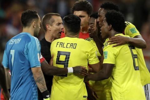 Colombian players complain to the referee Mark Geiger from U.S, during the round of 16 match between Colombia and England at the 2018 soccer World Cup in the Spartak Stadium, in Moscow, Russia, Tuesday, July 3, 2018. (AP Photo/Matthias Schrader)
