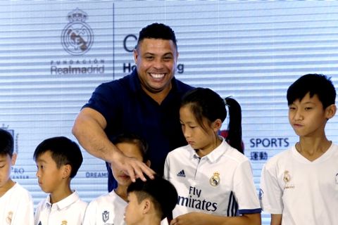 Brazilian football star Ronaldo Luis Nazario, center, plays with his fans during a promotional event for the Real Madrid Foundation Clinics in Hong Kong, Saturday, May 27, 2017. (AP Photo/Kin Cheung)