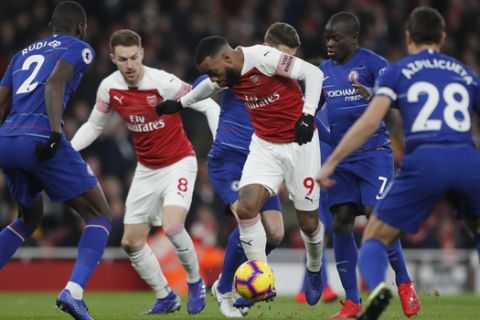 Arsenal's Alexandre Lacazette, centre, attempts to get through the Chelsea defence during the English Premier League soccer match between Arsenal and Chelsea at the Emirates stadium in London, Saturday, Jan. 19, 2019. (AP Photo/Frank Augstein)