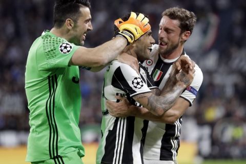 Juventus' scorer Dani Alves, center, and his teammates Claudio Marchisio, right, and Gianluigi Buffon, left, celebrate their side's 2nd goal during the Champions League semi final second leg soccer match between Juventus and Monaco in Turin, Italy, Tuesday, May 9, 2017. (AP Photo/Antonio Calanni)