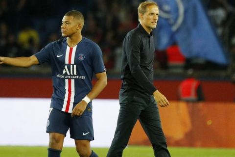 PSG's head coach Thomas Tuchel, right, walks on the field with his player Kylian Mbappe at the end of the French League One soccer match between Paris Saint Germain and Nimes at the Parc des Princes Stadium in Paris, Sunday, Aug. 11, 2019. PSG won 3-0. (AP Photo/Francois Mori)