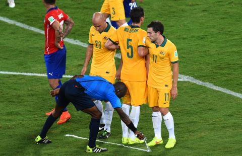 CUIABA, BRAZIL - JUNE 13:  Referee Noumandiez Doue sprays a temporary line for a free kick as Mark Bresciano, Mark Milligan and Tommy Oar of Australia form a wall during the 2014 FIFA World Cup Brazil Group B match between Chile and Australia at Arena Pantanal on June 13, 2014 in Cuiaba, Brazil.  (Photo by Stu Forster/Getty Images)